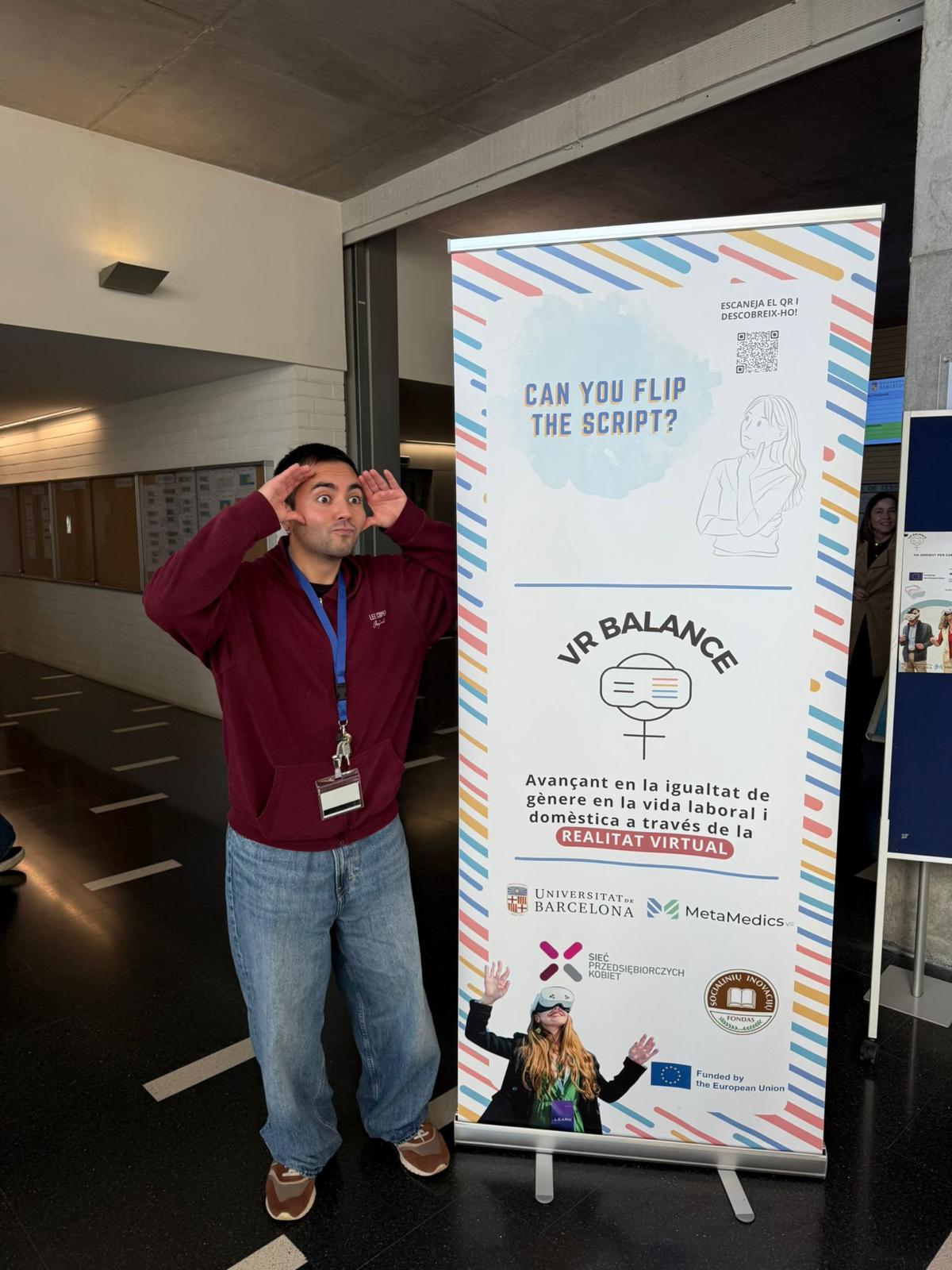 A participant next to the VR Balance roll-up banner at the University of Barcelona.